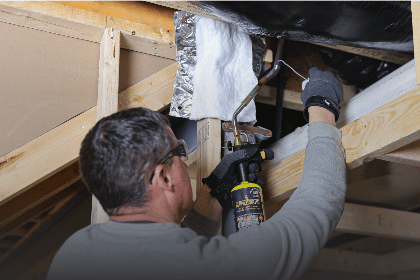 Contractor using a hand torch to fix pipe