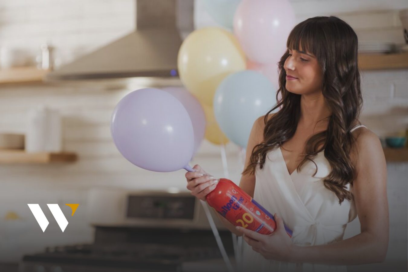 woman inflating balloons with helium tank