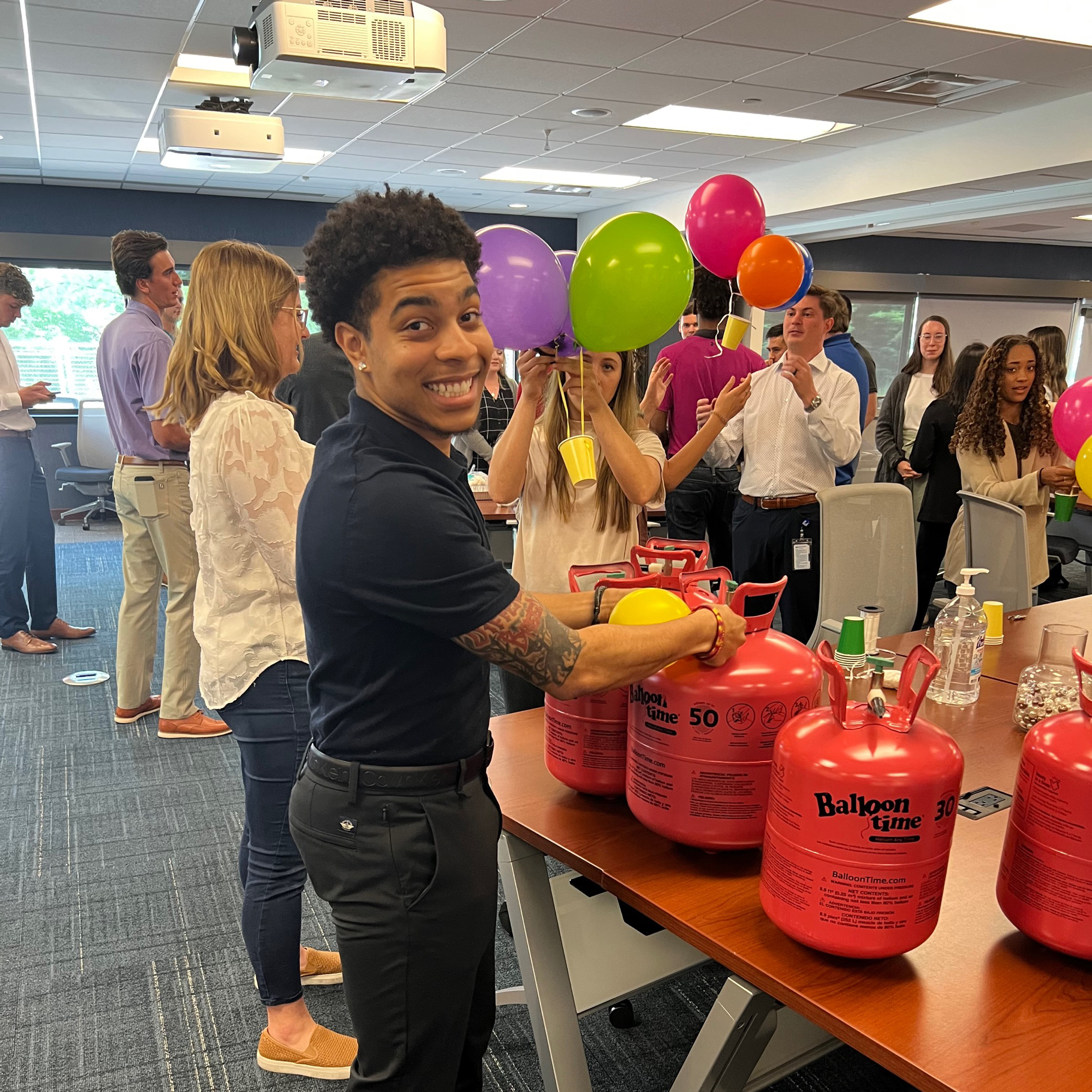 Intern blowing up helium balloons