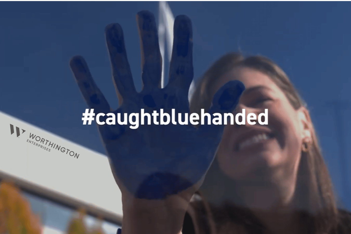 woman placing blue handprint on camera lens
