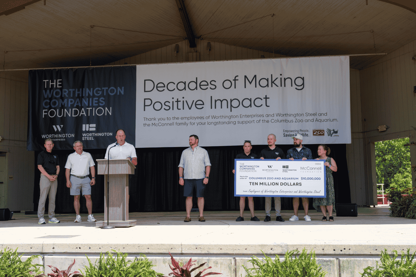 Leaders presenting large financial gift on stage