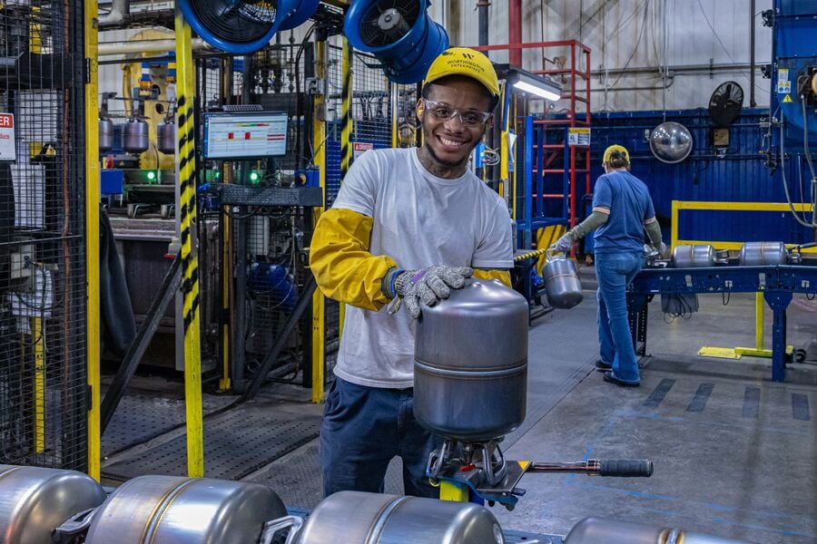 Male employee in PPE holding a cylinder