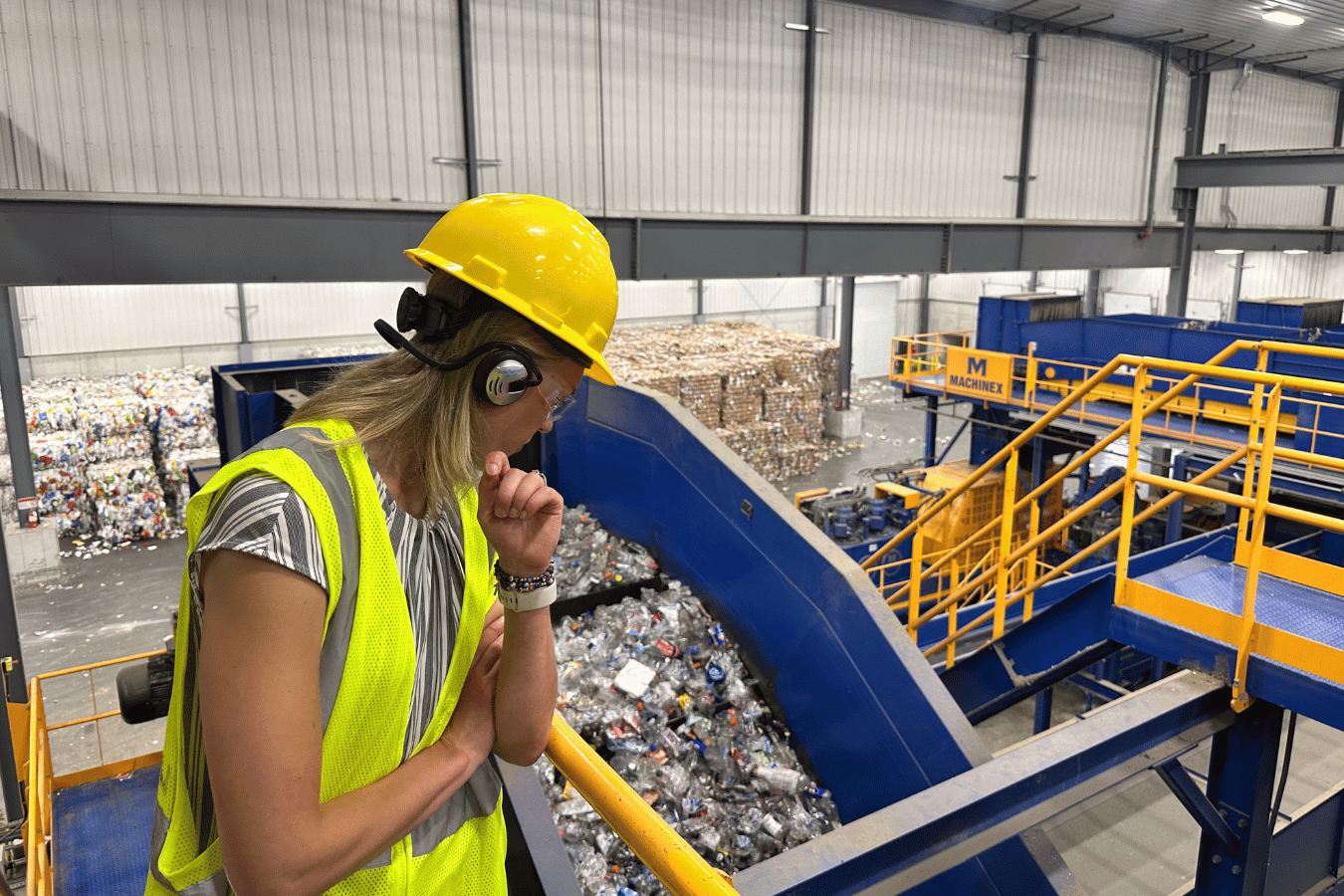 Employee in hard hat overlooking waste facility